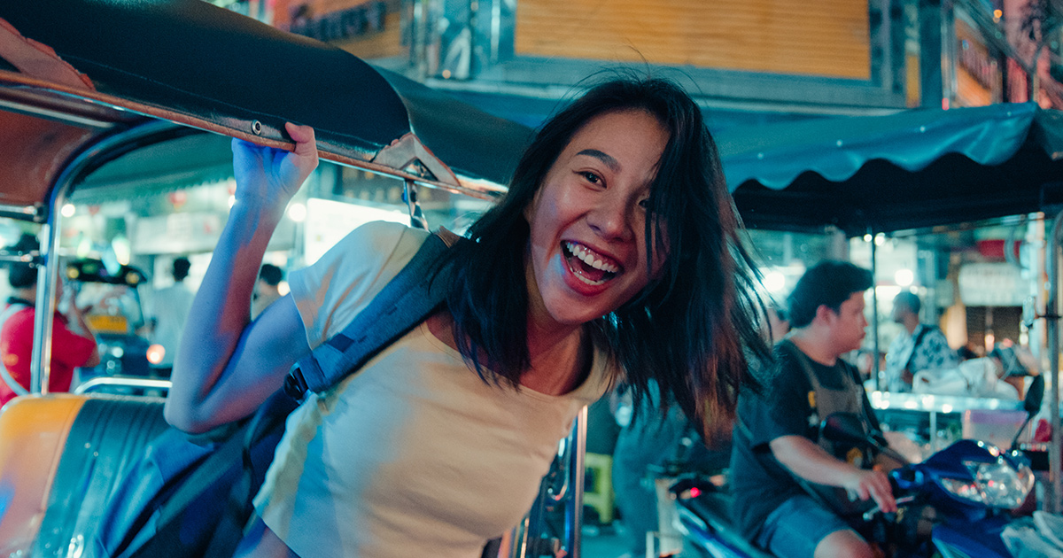 Traveler exploring local Thai market with digital app interface overlay